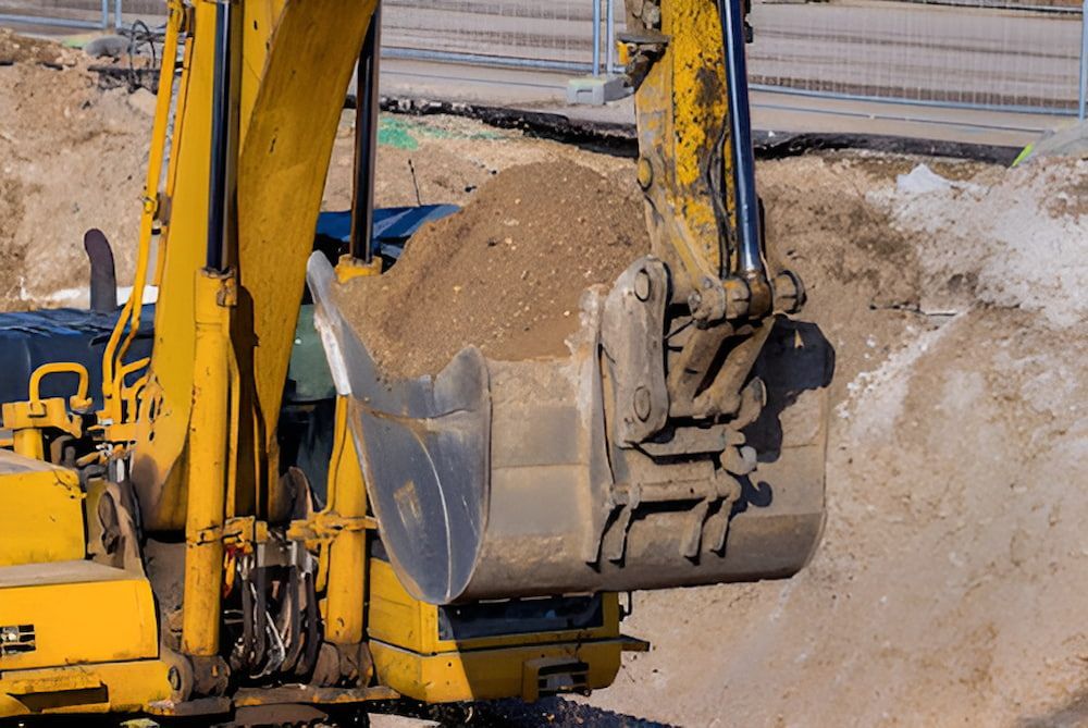 A Yellow Excavator Is Loading Dirt Into Its Bucket — Jeff Thompson Excavator Hire Pty Ltd In Pink Lily, QLD