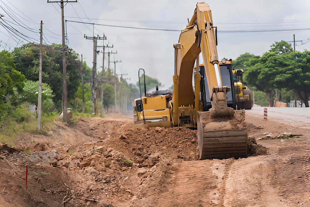 A Yellow Excavator Is Working On A Dirt Road — Jeff Thompson Excavator Hire Pty Ltd In Pink Lily, QLD