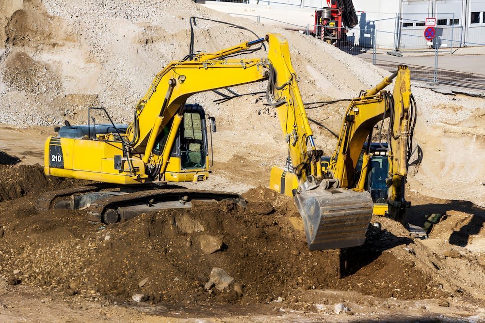Two Yellow Excavators Are Working On A Construction Site — Jeff Thompson Excavator Hire Pty Ltd In Pink Lily, QLD