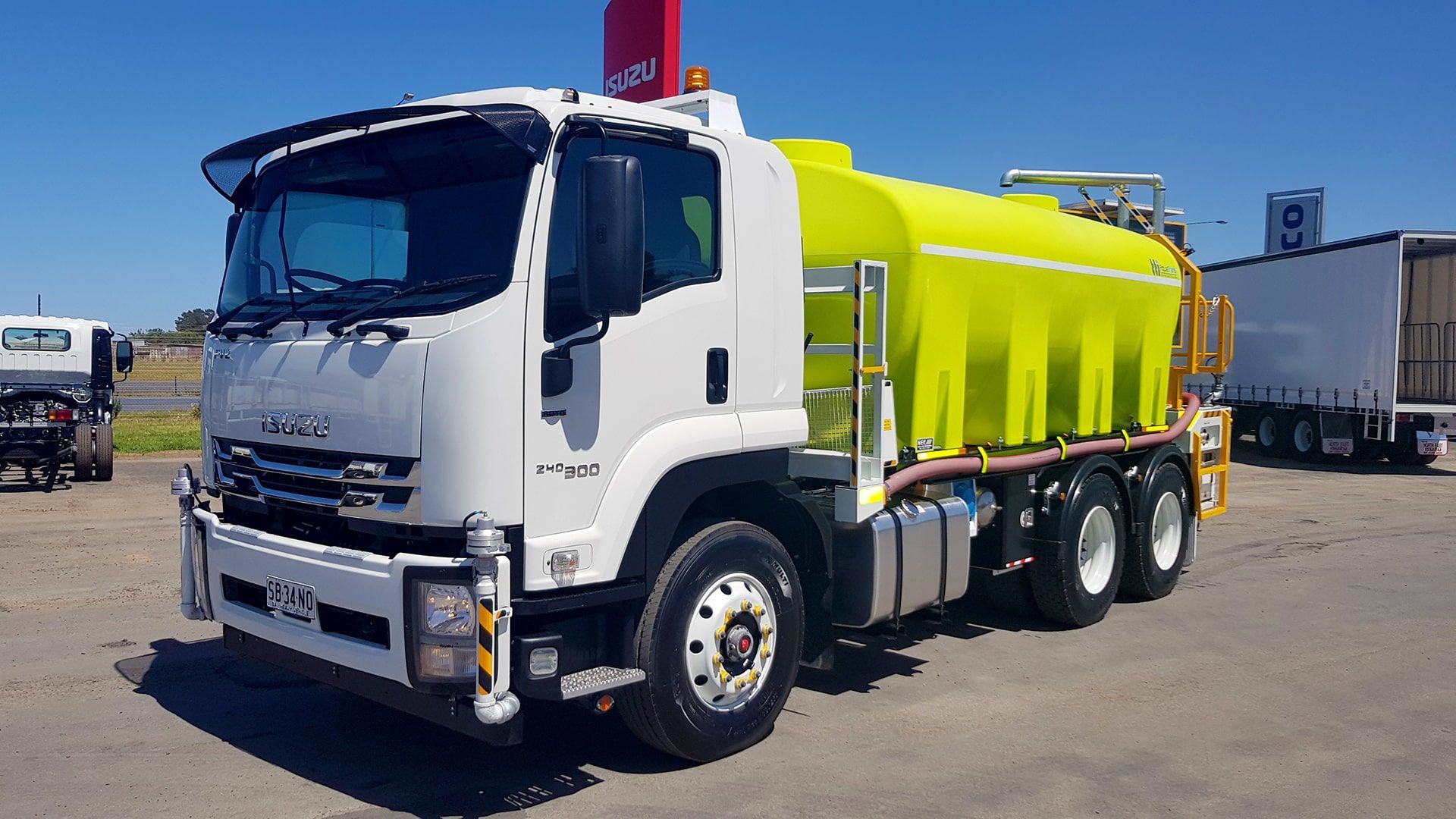 A yellow and white truck is parked in a parking lot.