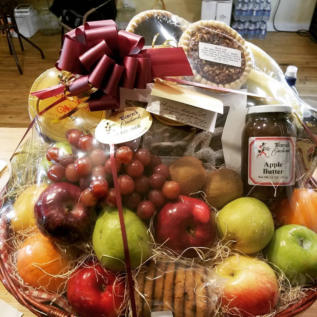 Fruit and baked goods gift basket with a maroon bow.