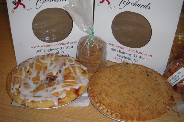 Two pies and cookies in front of white bags from Wyckoff Orchards.