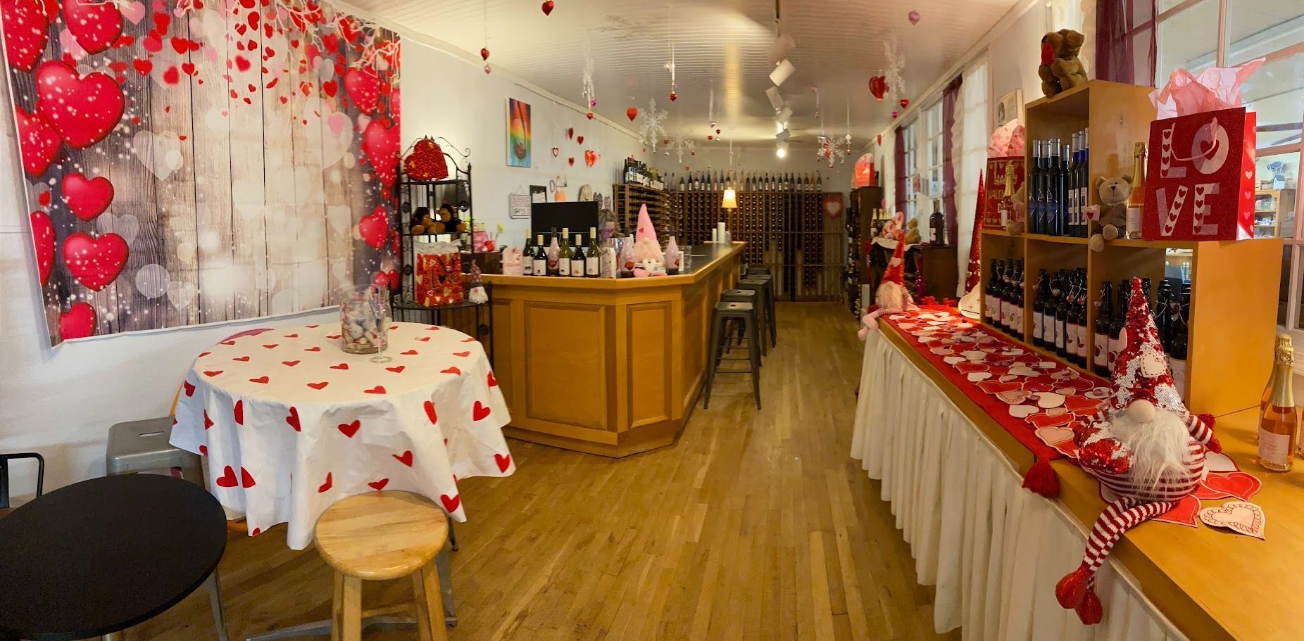 Wine shop decorated for Valentine's Day with hearts, balloons, and a bar.