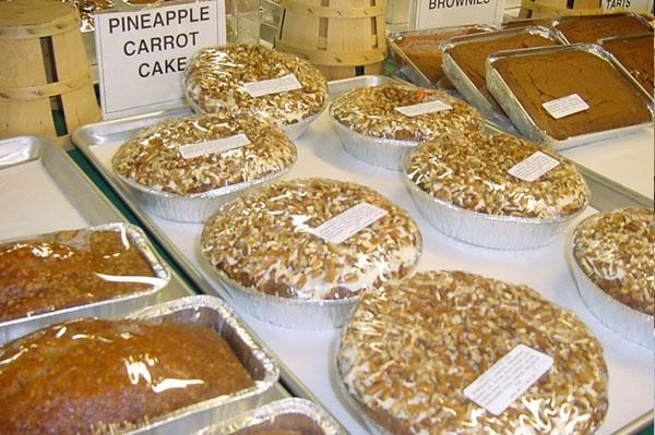 Cakes on display, including pineapple carrot cake, in a bakery setting.