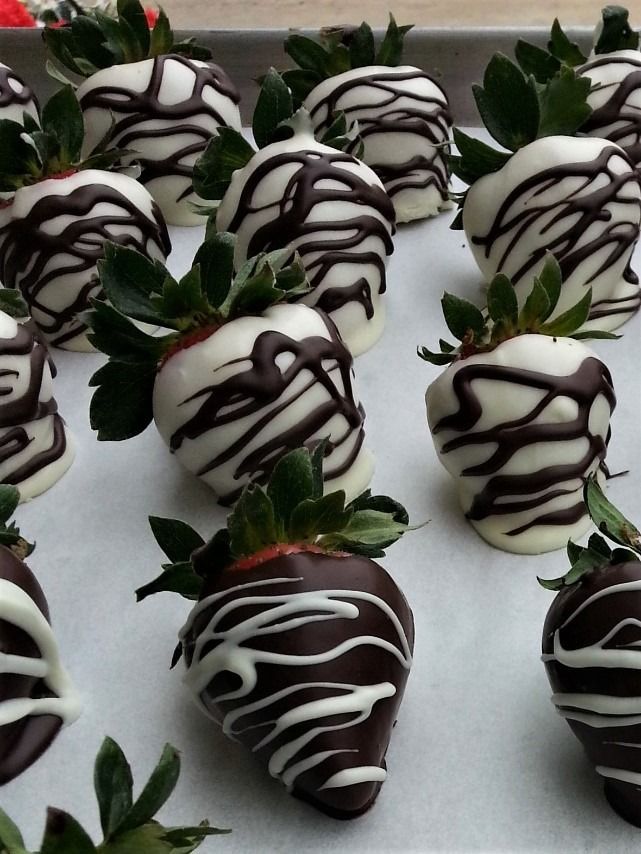 Chocolate-covered strawberries: white chocolate coating with dark chocolate drizzle, arranged on a tray.