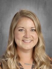 A woman with long blonde hair is smiling for a picture.