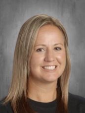 A woman with long blonde hair is smiling for a picture.