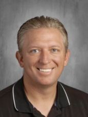 A man in a black shirt is smiling for a picture.