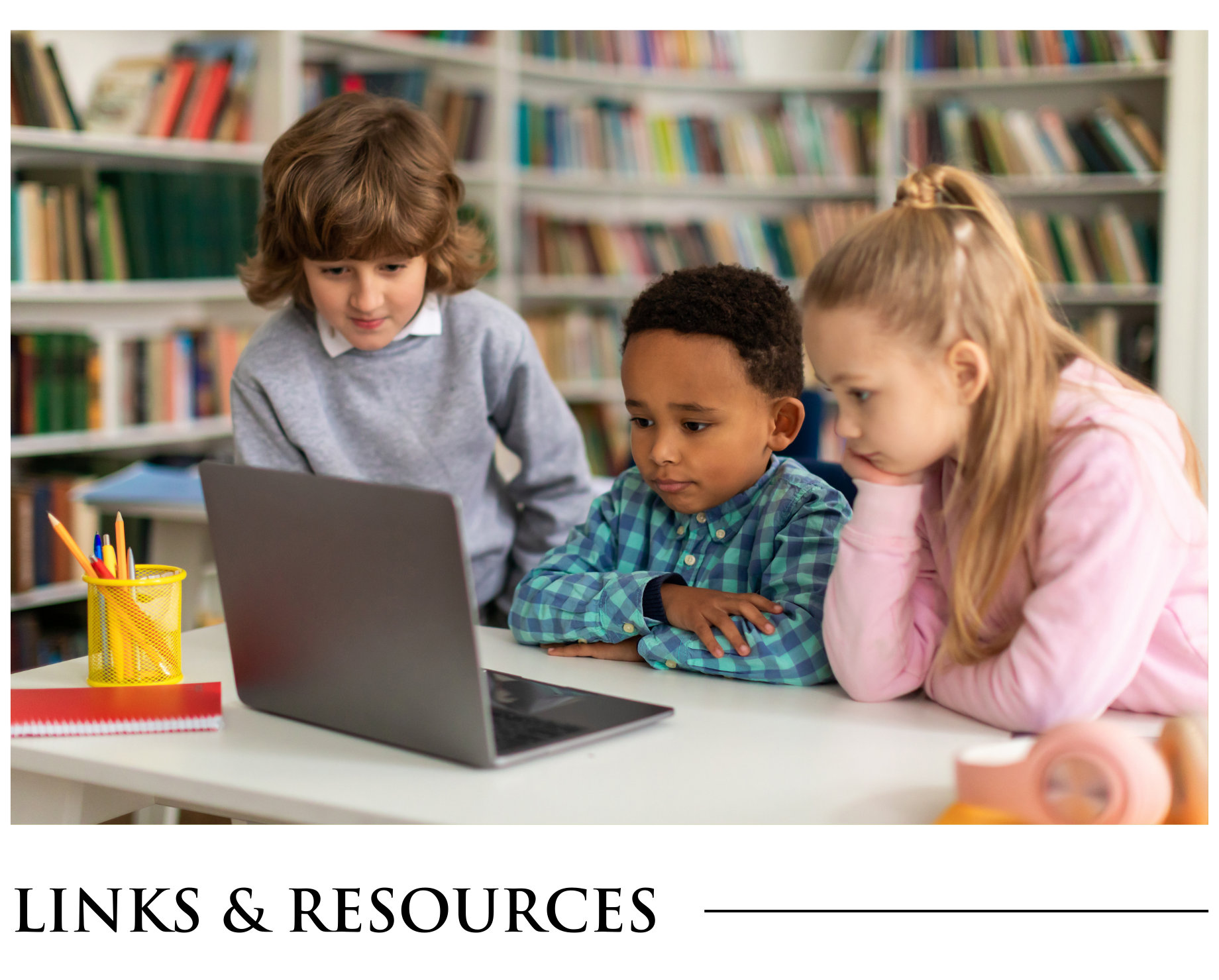 A group of children are sitting at a table looking at a laptop computer.