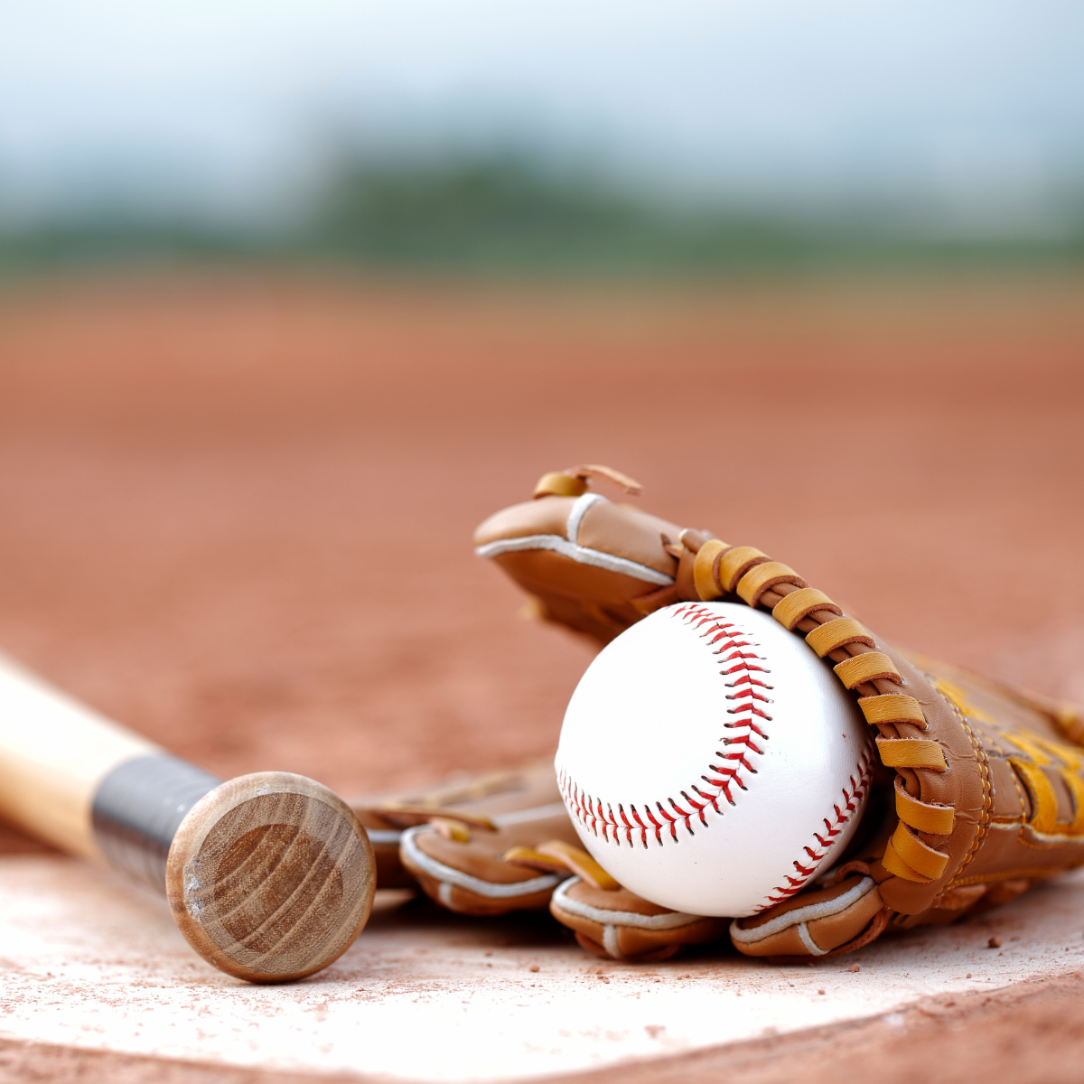 A baseball in a glove on a baseball field