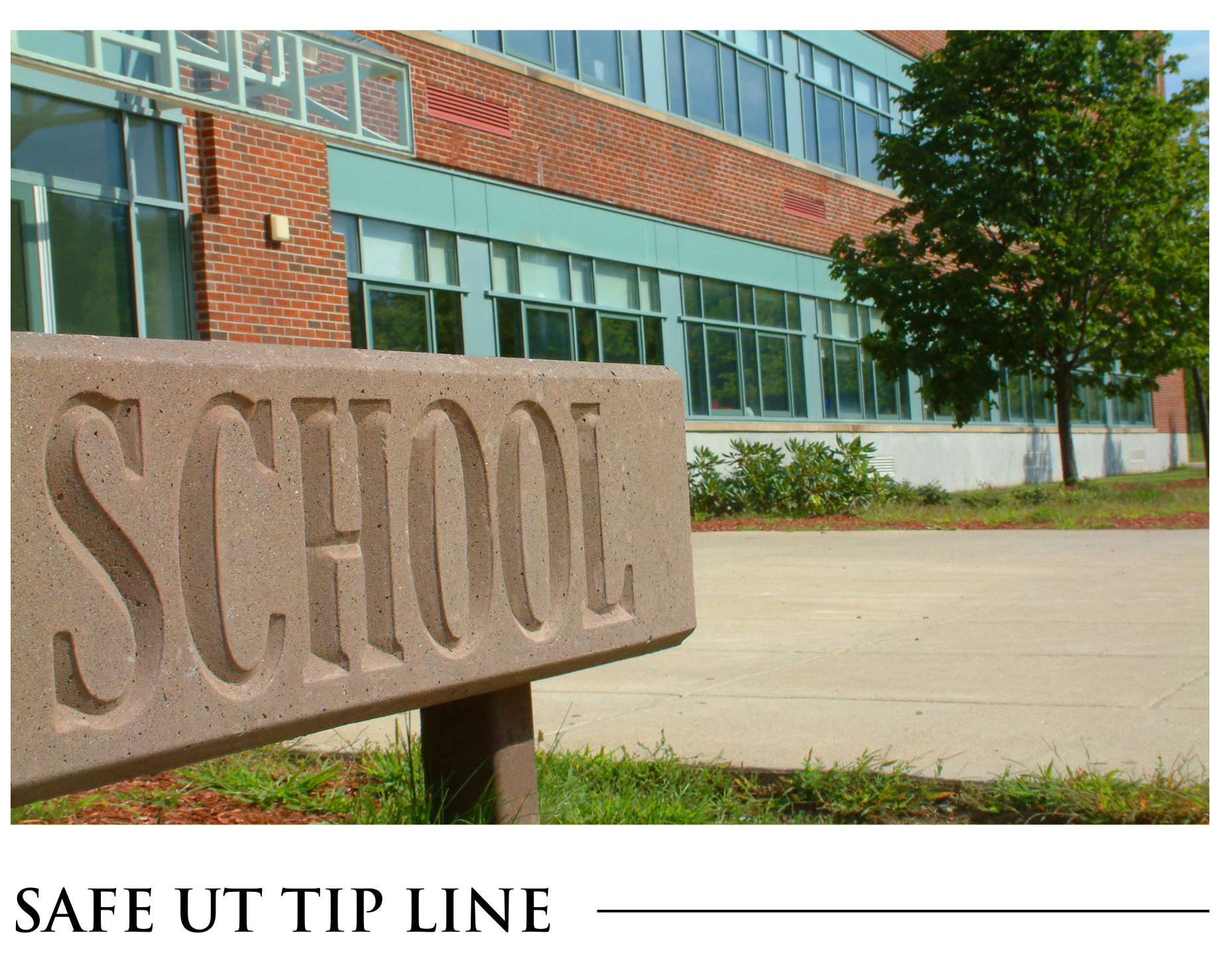 A stone sign that says school in front of a school