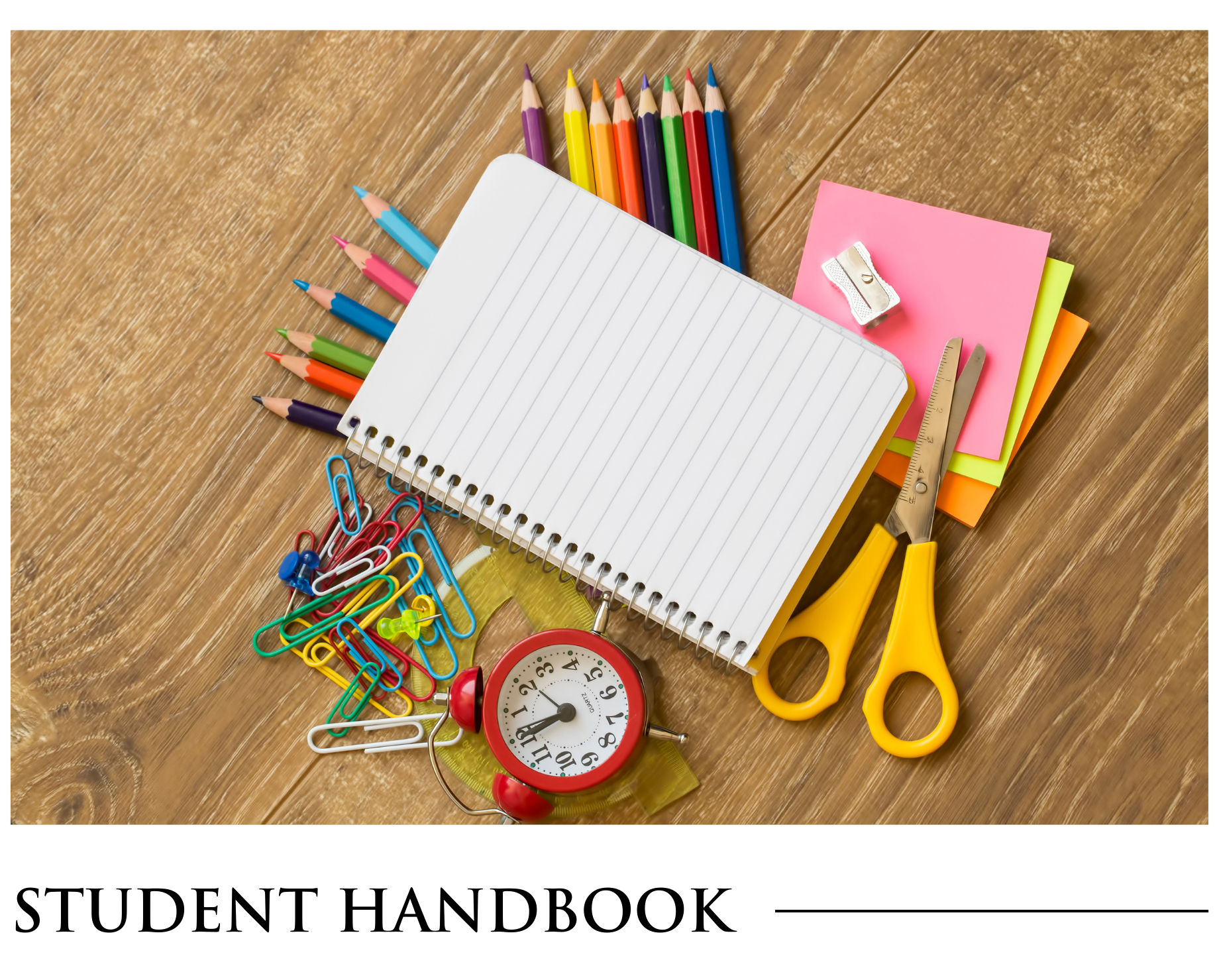 A student handbook is sitting on a wooden table.