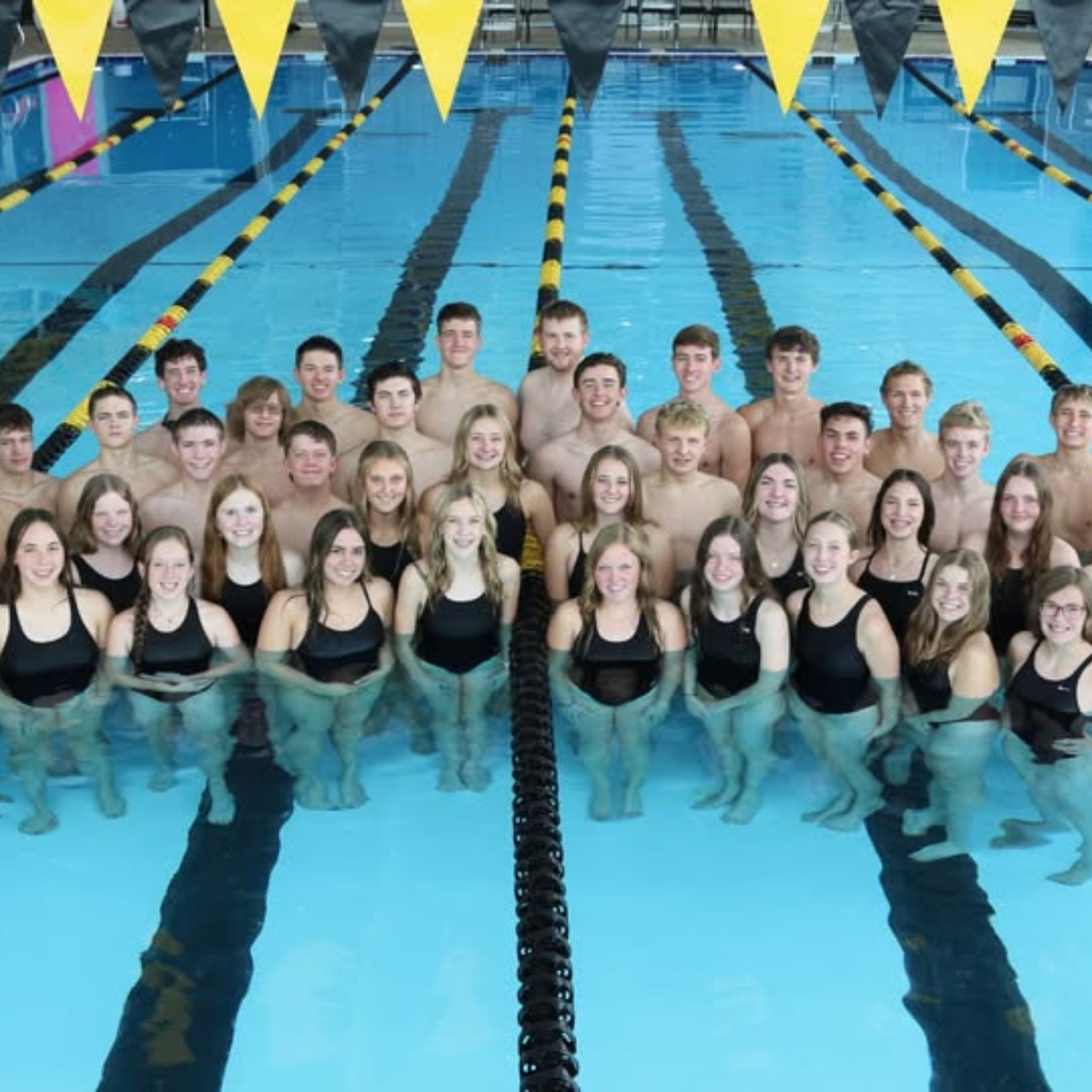 A group of people are posing for a picture in a swimming pool