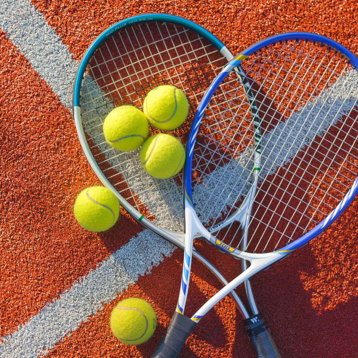 Two tennis rackets and three tennis balls on a tennis court