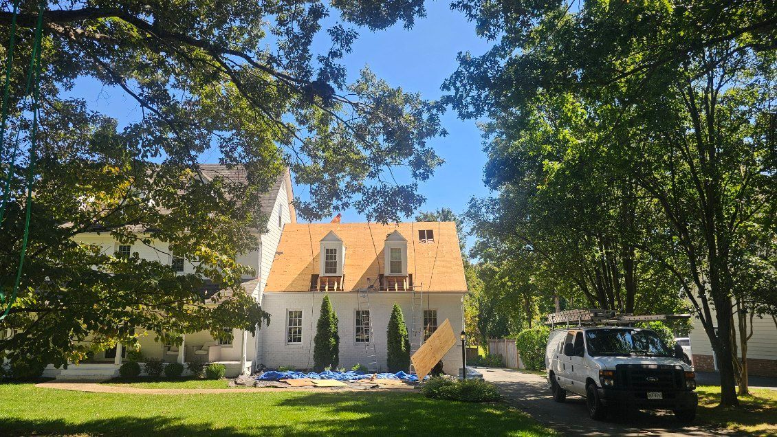 A two-story white house with a partially re-shingled orange roof and dormer windows - BittnerSweet Co