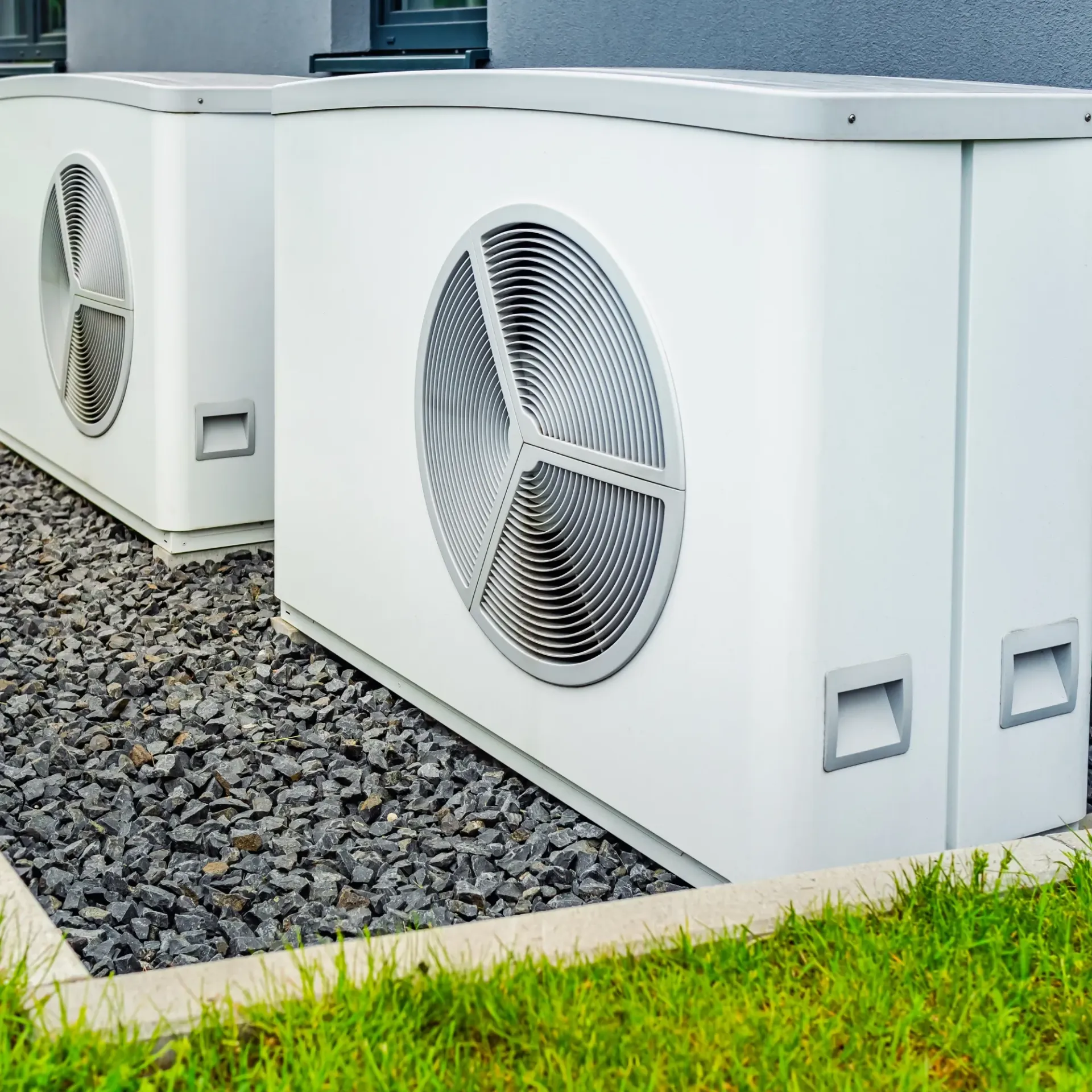 Comfort Air Solution LLC - Two white air conditioners are outside of a building