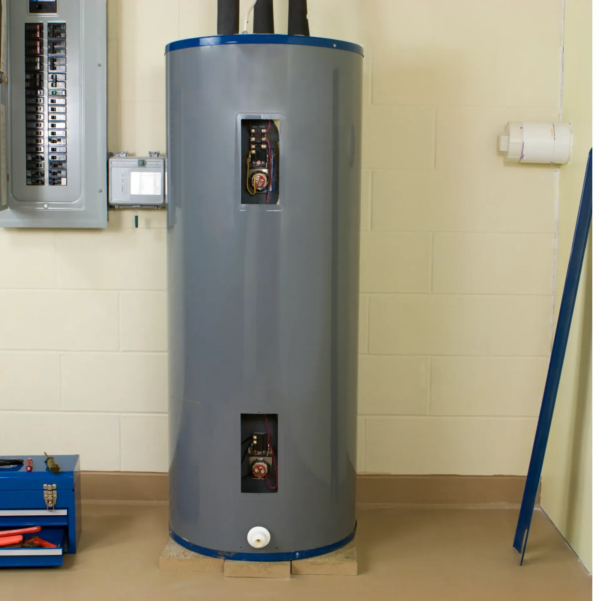 Comfort Air Solution LLC - A large gray water heater is sitting in a basement next to a toolbox.
