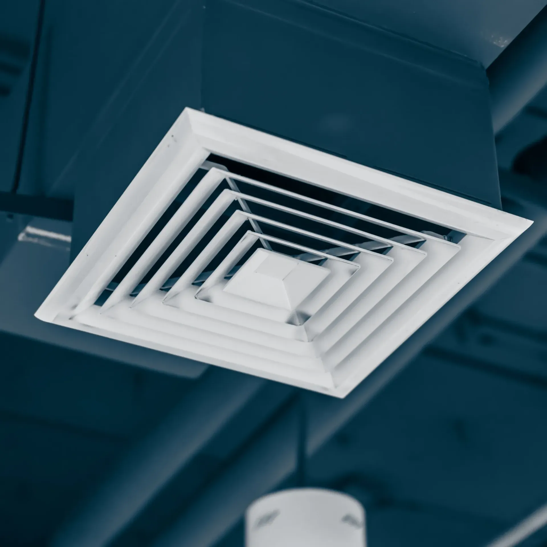 Comfort Air Solution LLC - A white air vent is hanging from the ceiling of a room.