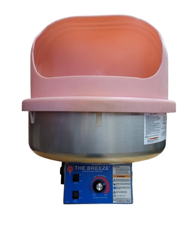 a person is making pink cotton candy in a machine .