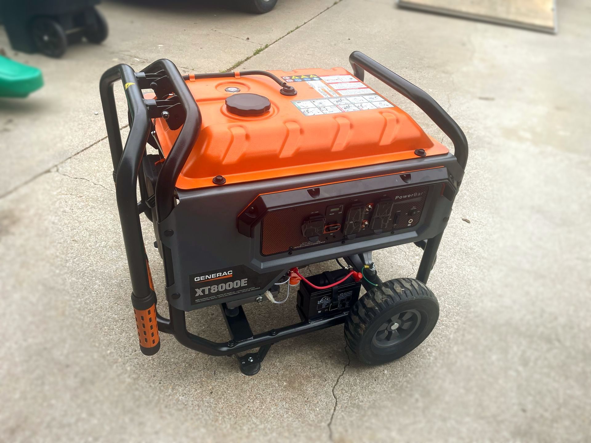 a red portable generator is sitting on a sidewalk .