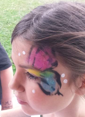 a little girl with a butterfly painted on her face .