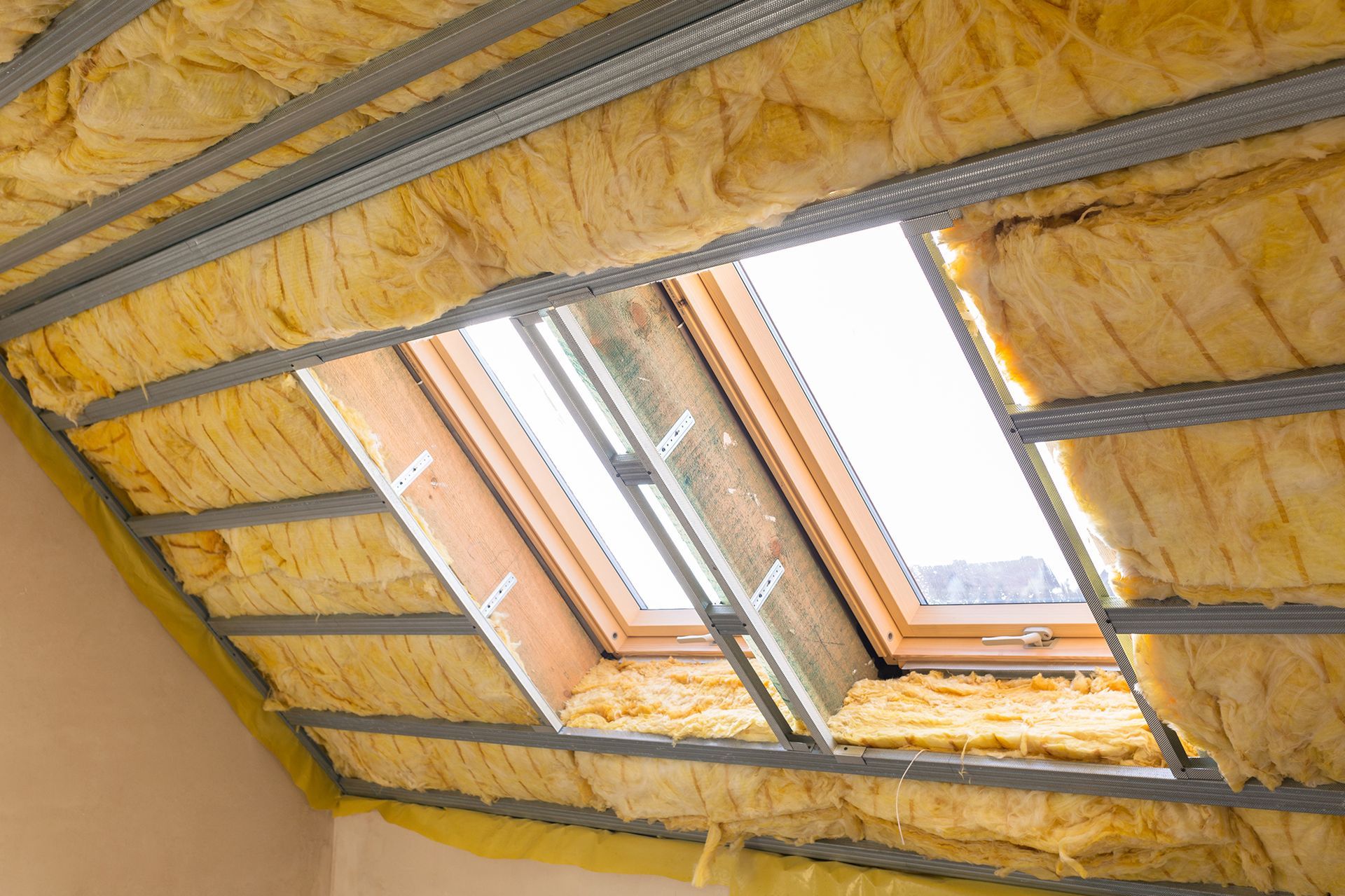 A ceiling with a skylight and insulation on it.