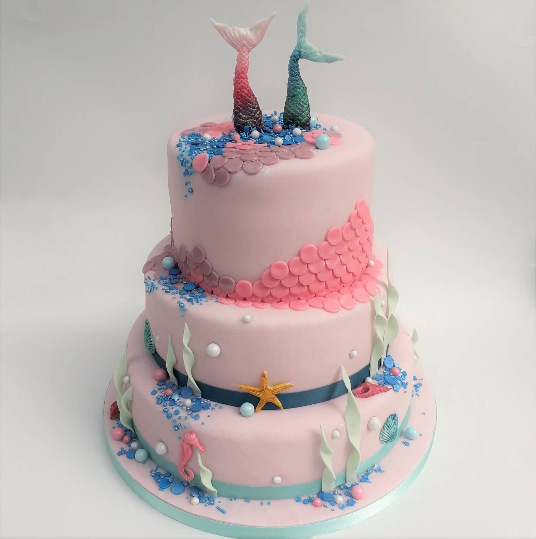 Pink and blue shimmery 3 tiered mermaid cake. Made by A Cherry On Top