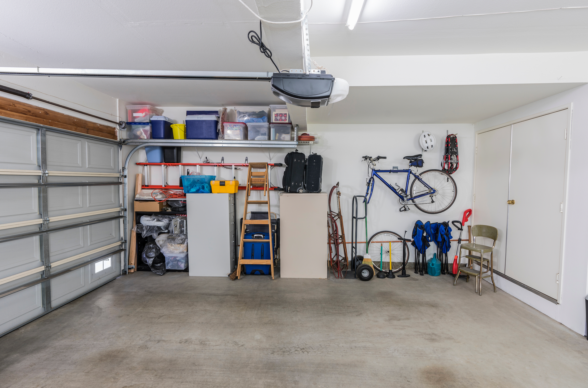 There is a bicycle hanging on the wall in the garage.