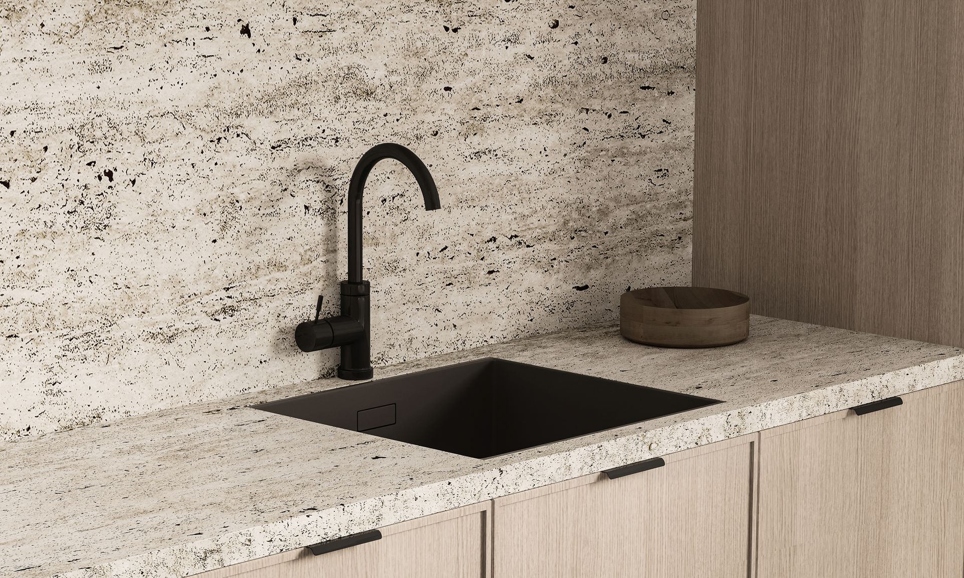 Black sink and faucet in a kitchen with a speckled countertop and wood cabinets.