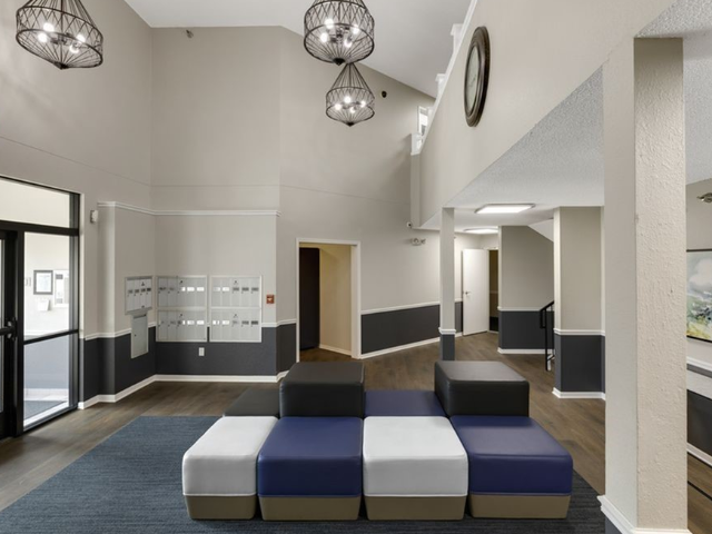 Interior apartment community lobby with modular seating and mailboxes.
