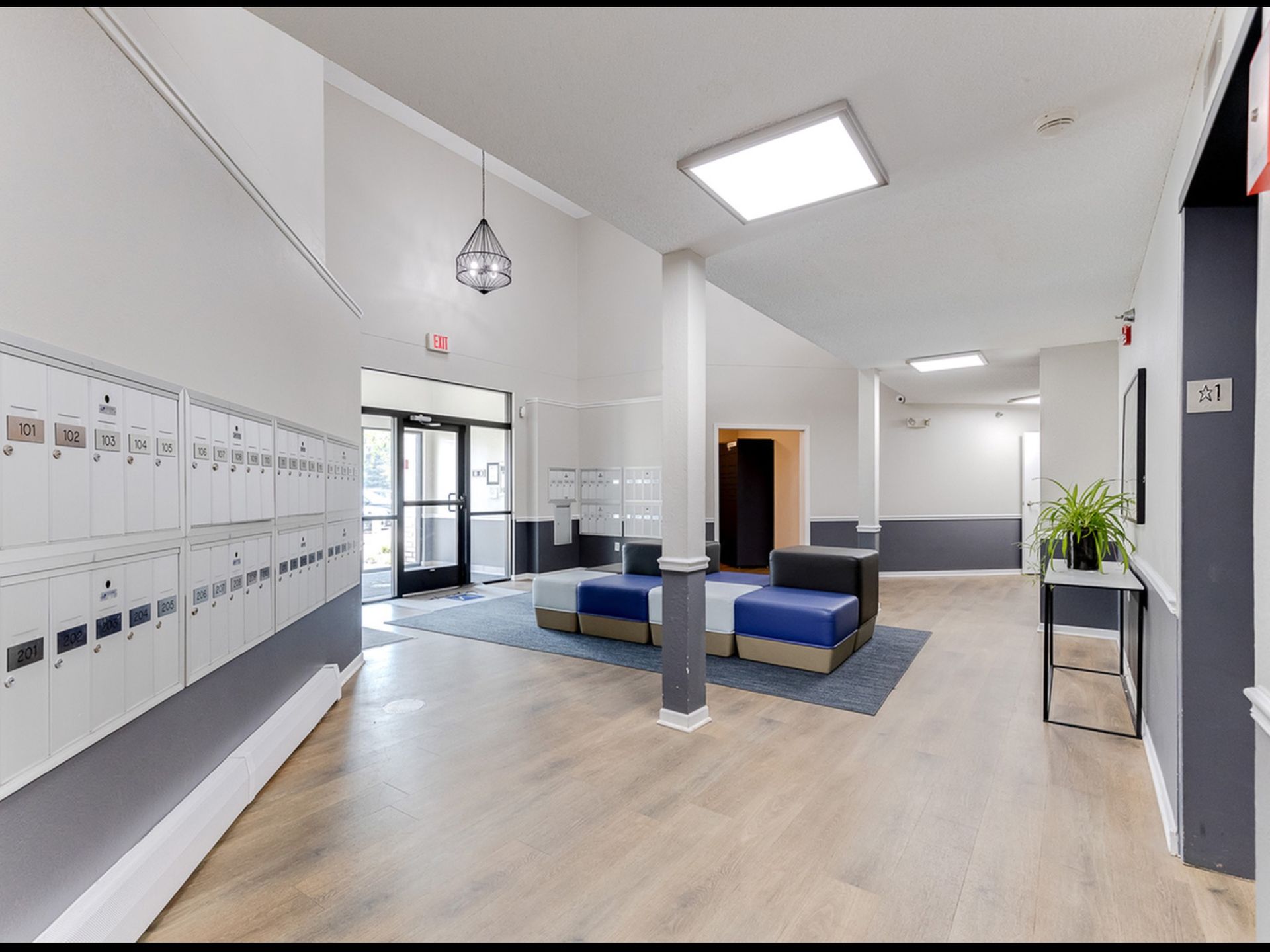 Lobby area with wall of mailboxes, seating, and entrance doors.