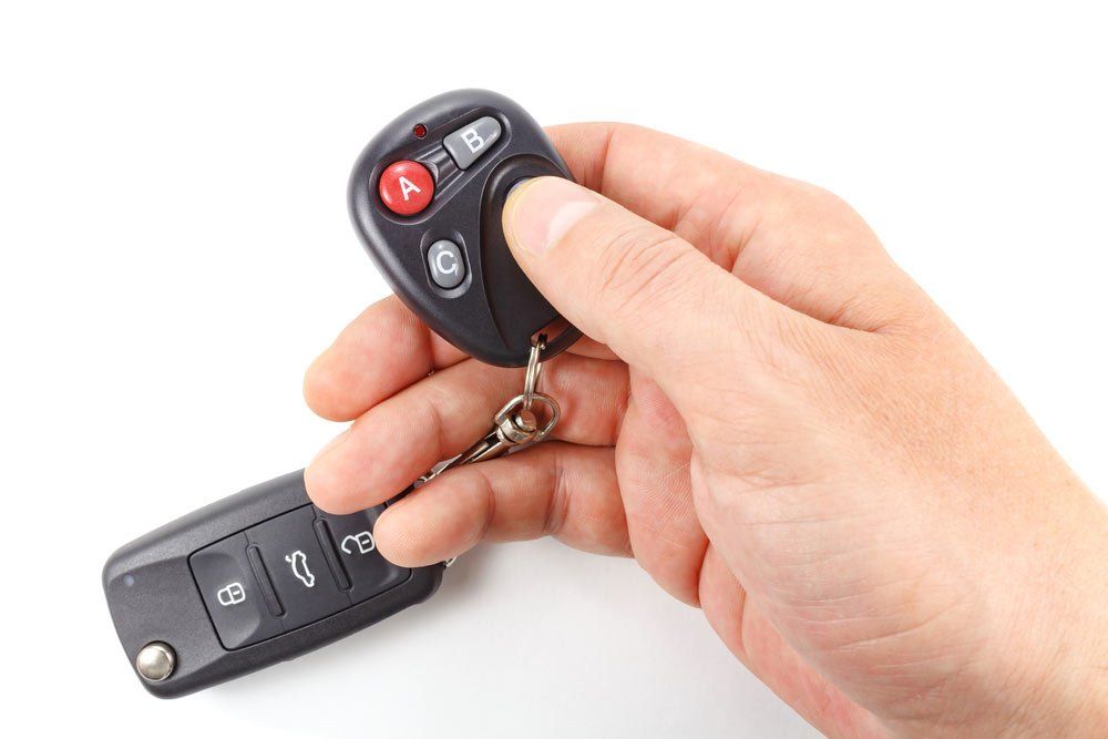 Man Presses A Garage Door Remote Button — Garage Doors in Wollongong, NSW