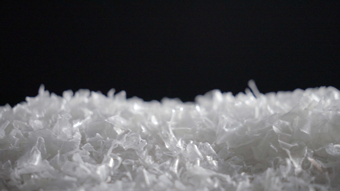 a pile of white shredded plastic against a black background