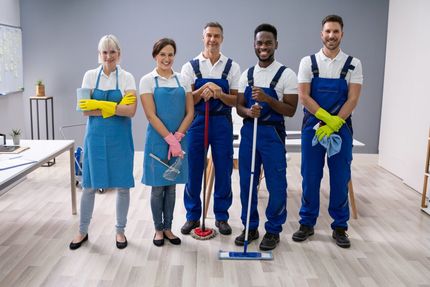 A man is shaking hands with a plumber in a kitchen.