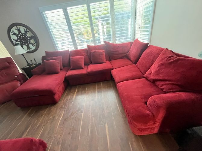 at home upholstery cleaning A living room filled with red furniture and a large red sectional couch.