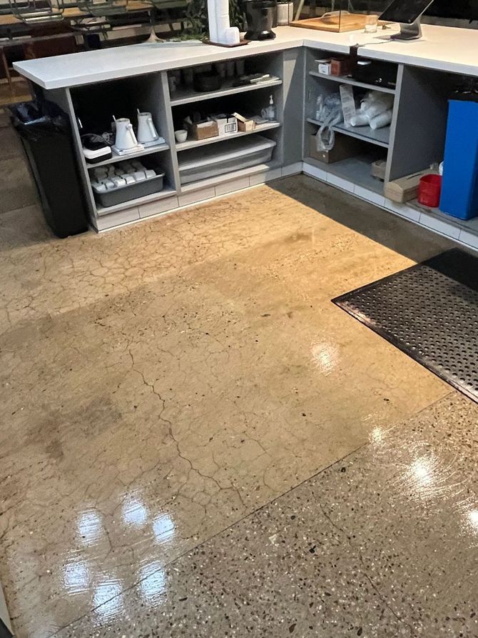 A kitchen with a shiny concrete floor and a counter cleaning house cleaners