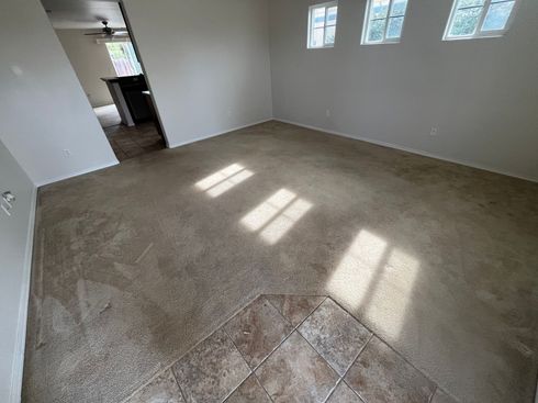 clean and services A living room with a carpeted floor and tile floor.