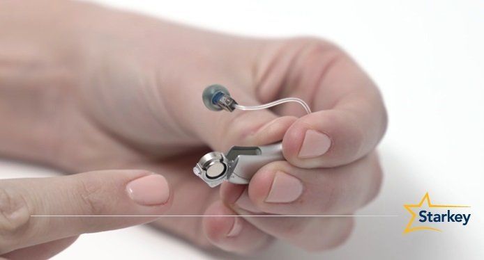 Doctor Holding Hearing Aid — AR/OK — Graham Hearing Services, Inc.