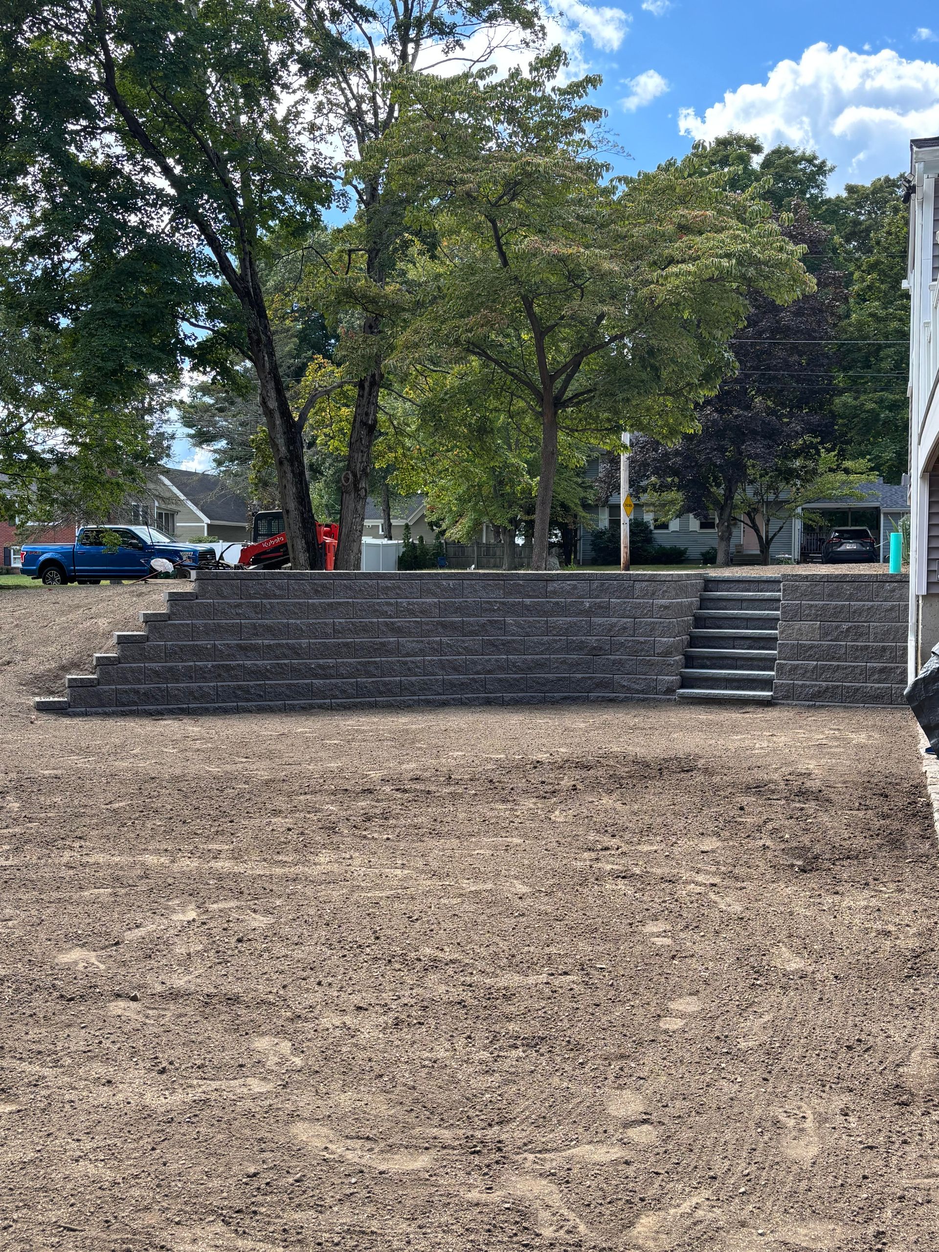 Wooden steps ascending a hillside. The steps are bordered by wooden planks.