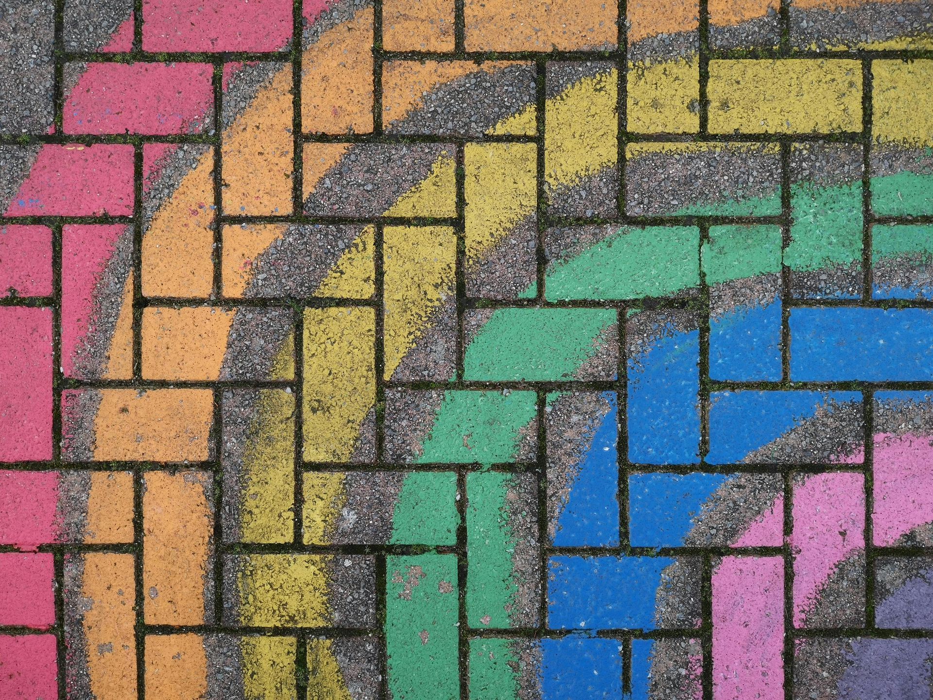 Colorful curved brick pavement pattern in pink, orange, yellow, green, blue, and purple.