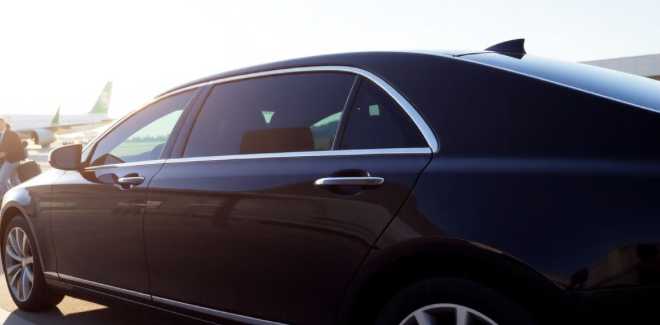 black luxury sedan waiting at the airport for clients