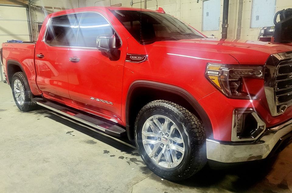 A red pickup truck is parked in a garage.