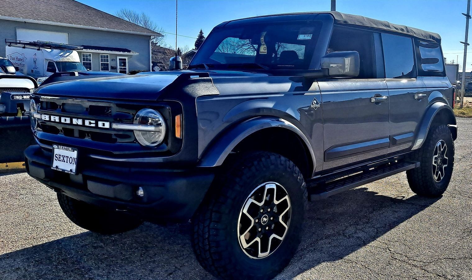 A black ford bronco is parked in front of a building.