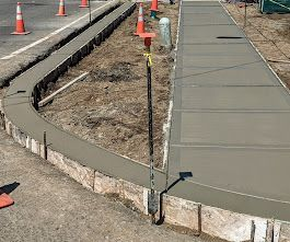 A concrete sidewalk is being built on the side of a road.