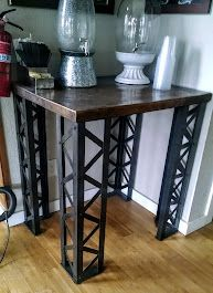 A wooden table with metal legs is sitting on a wooden floor in a room.