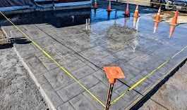 A concrete walkway is being built next to a body of water.
