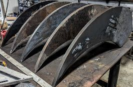 A bunch of metal pieces are sitting on top of a wooden table.