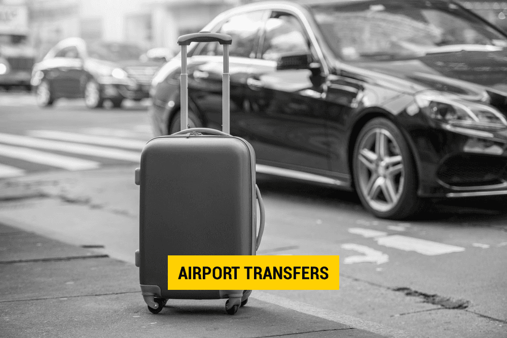 A suitcase is sitting on the side of the road next to a car.