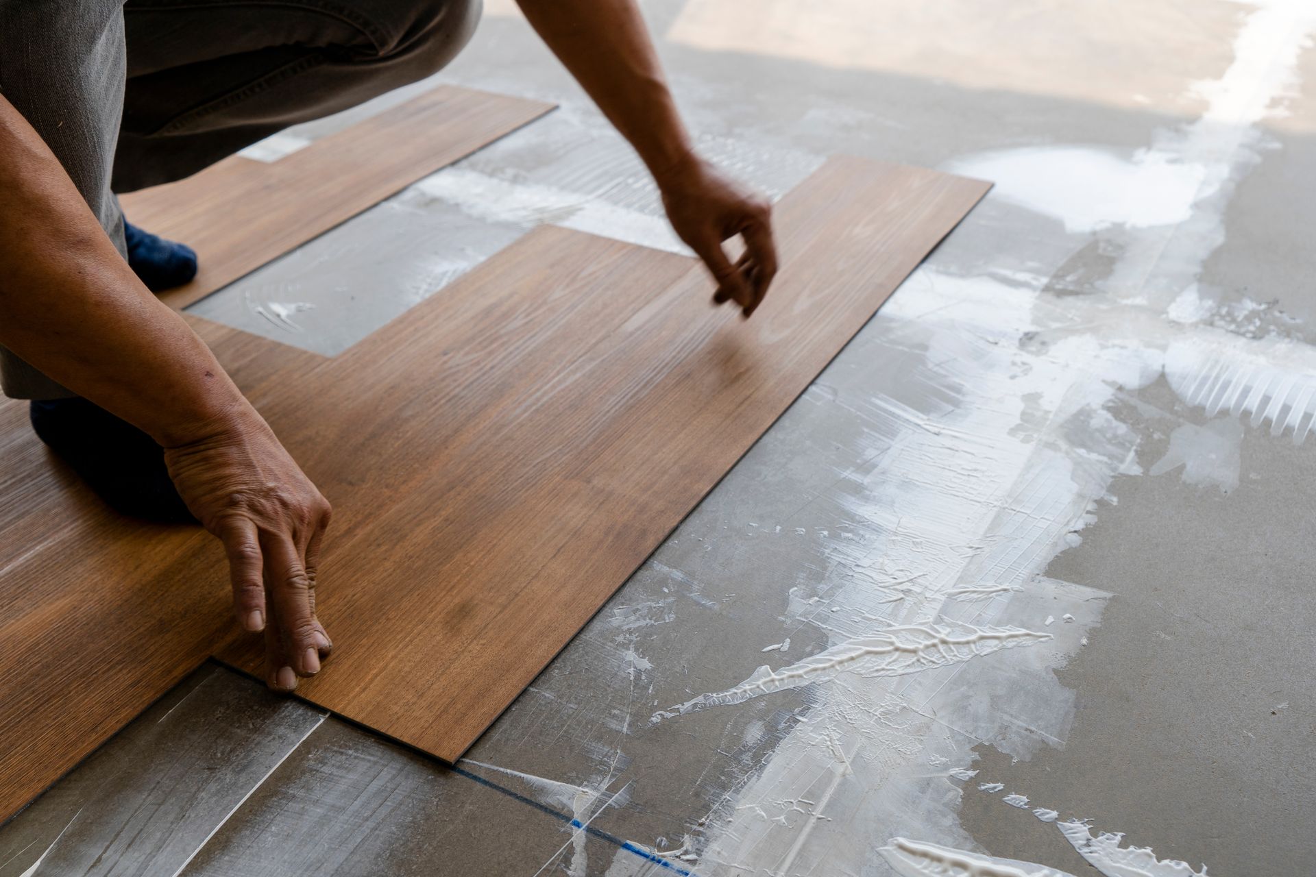 Step of vinyl floor tiles installation working on site