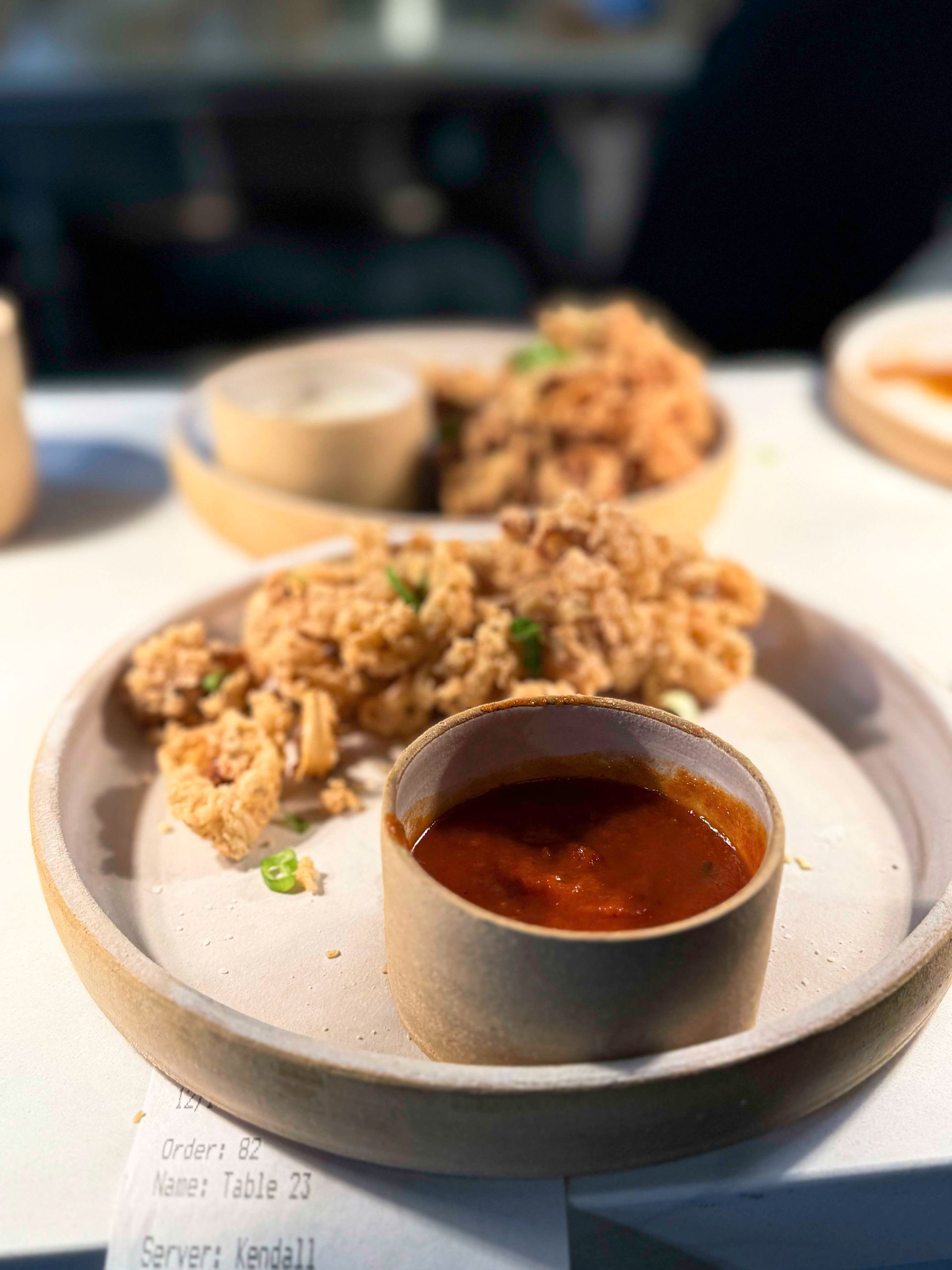 Fried calamari with dipping sauce on a plate.